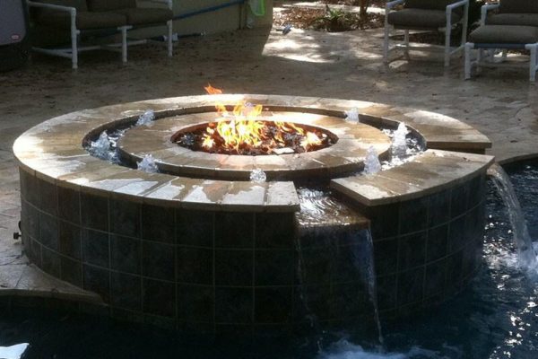 fire pit surrounded with water next to pool